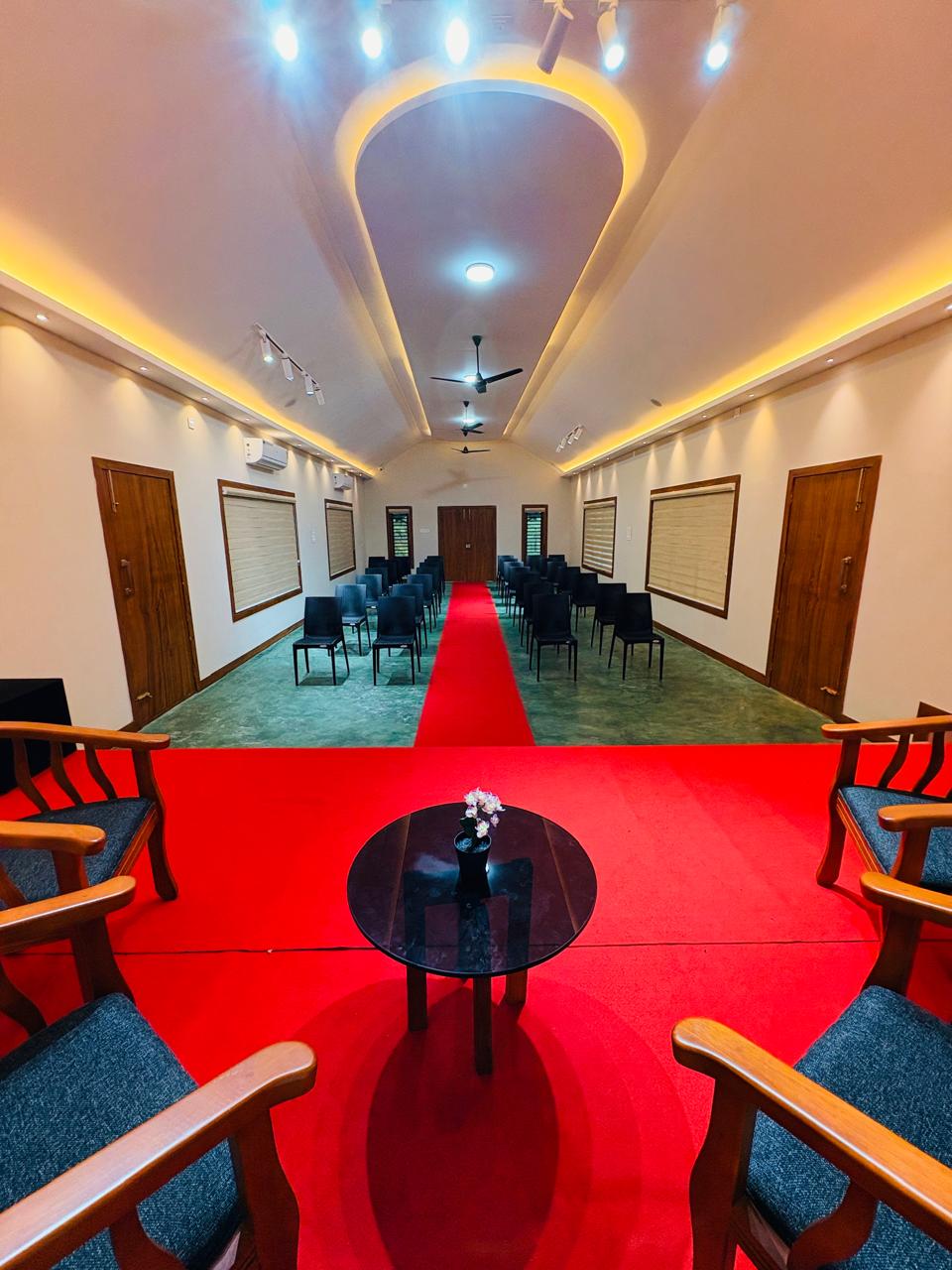 Spacious guest room with modern amenities and comfortable seating at JKR Gardens Resort Kerala