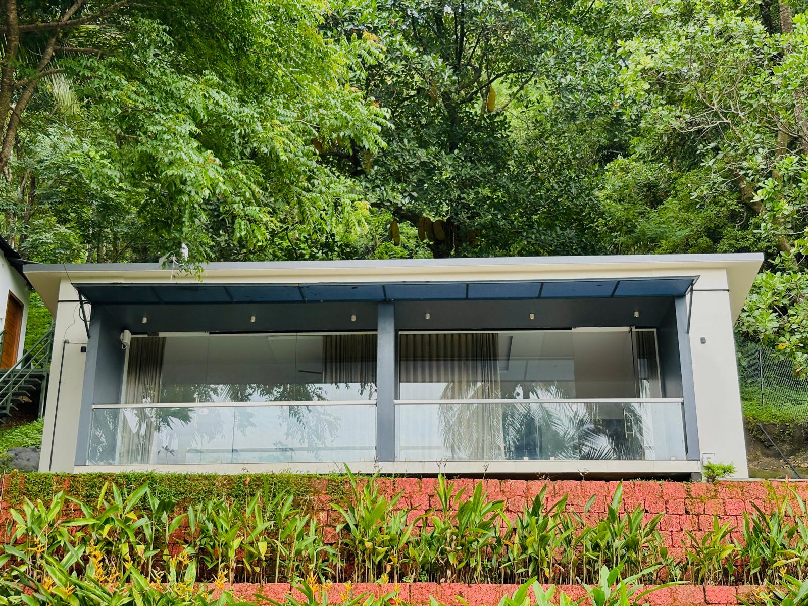 King-size bed room at JKR Gardens Resort Kerala with stylish accents and scenic window view